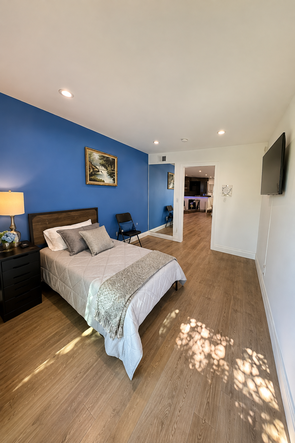 Private bedroom with a soft blue accent wall, single bed and nightstand